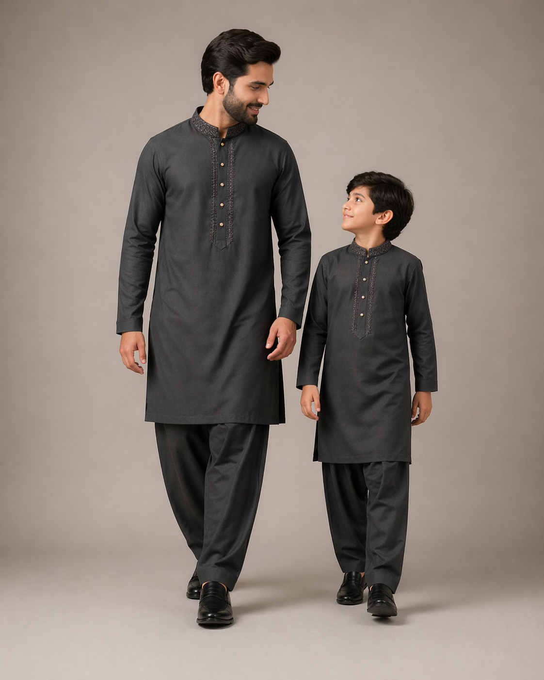 Man and child wearing matching dark gray traditional outfits
