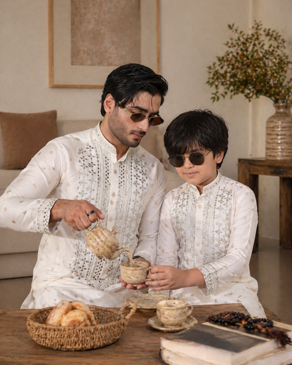 Man and child in matching white traditional outfits