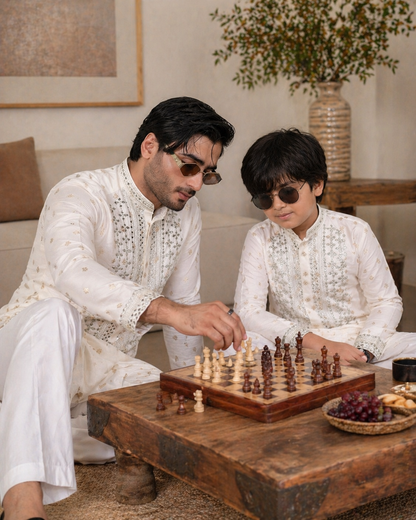 Man and child playing chess in a living room setting