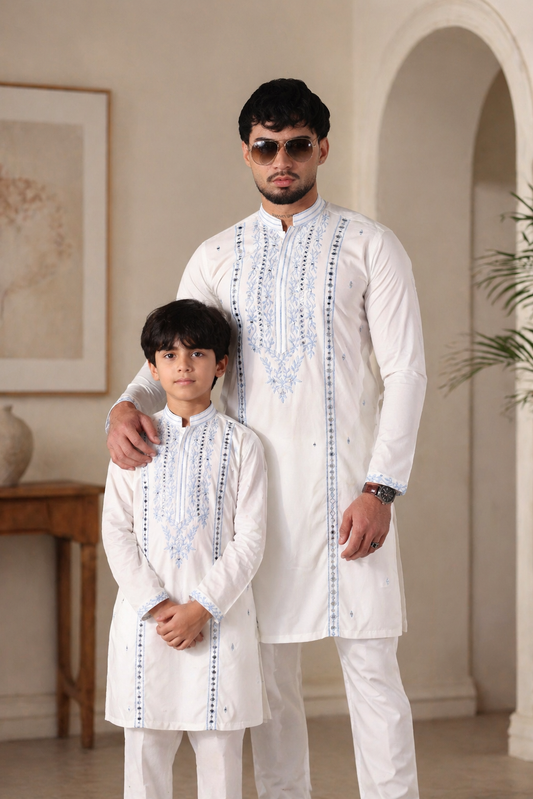 Man and child wearing white embroidered outfits