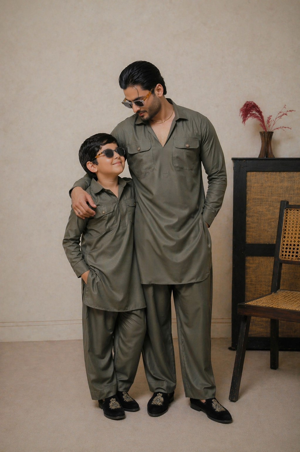Man and child in matching green outfits standing together indoors.
